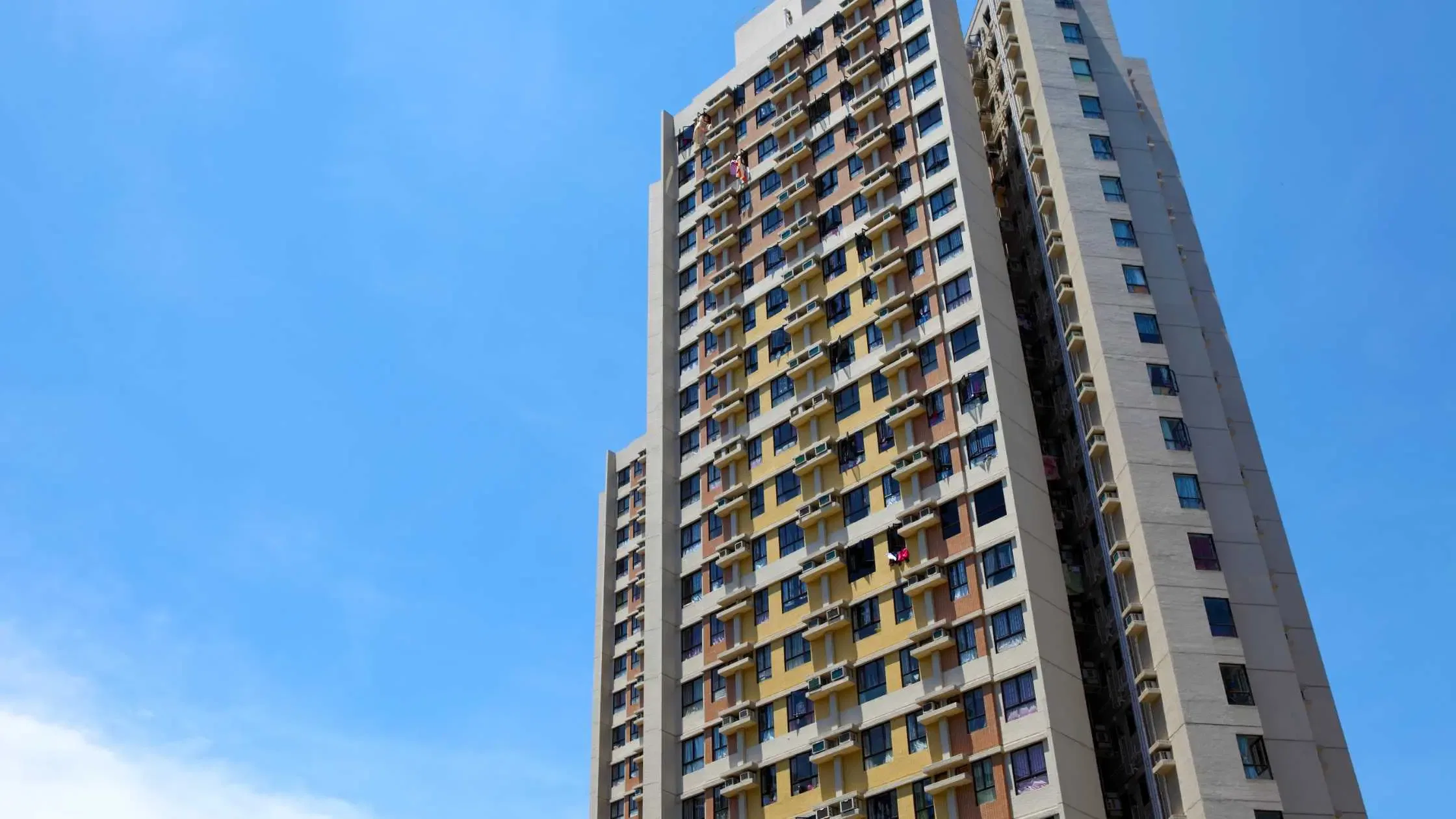 High-rise apartment building under a clear blue sky.