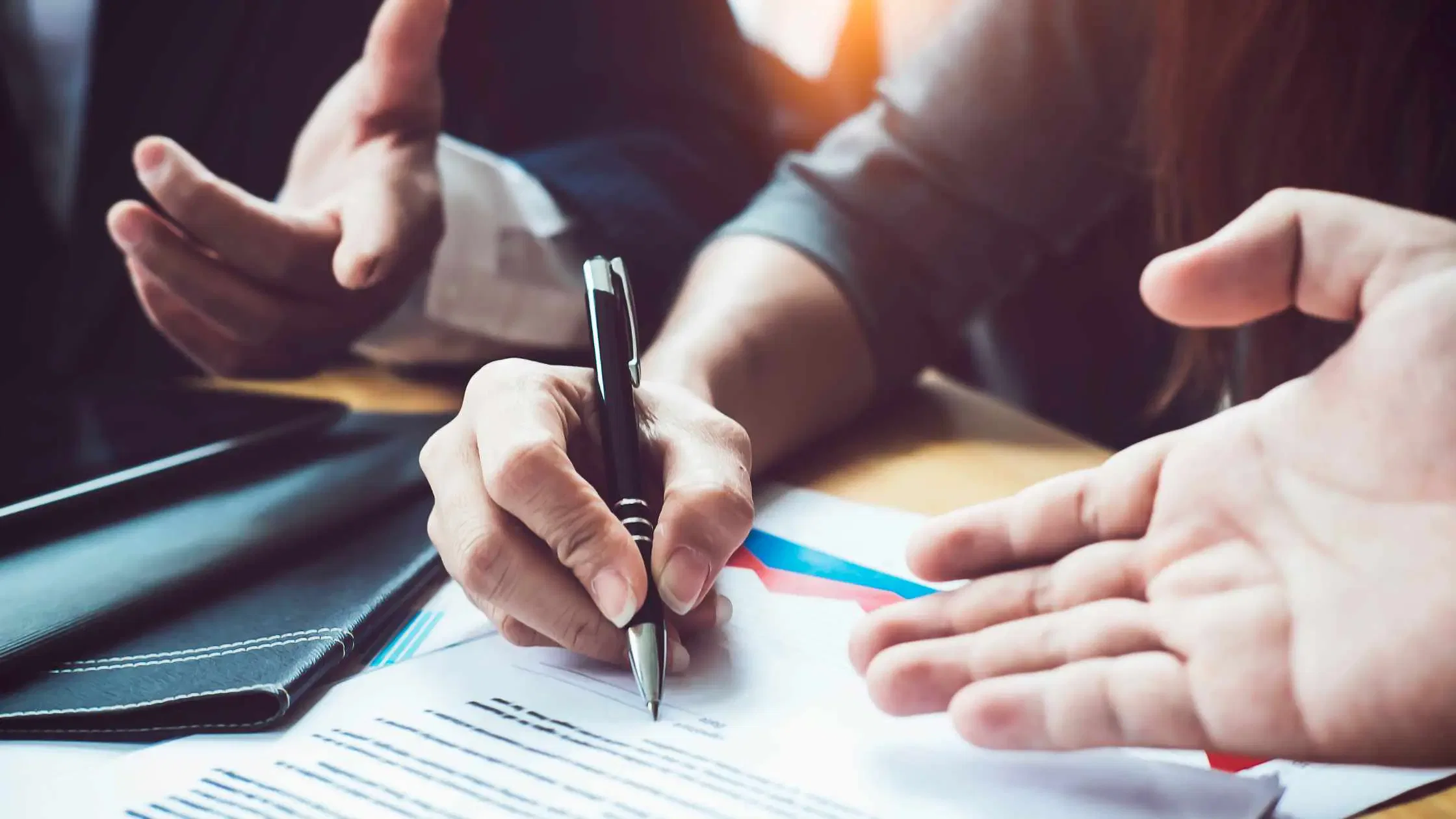 Businesspeople reviewing contract, signing agreement