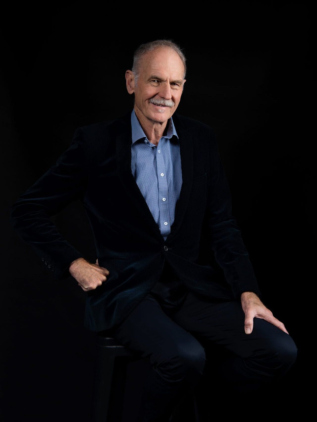 Smiling senior man in a dark suit and blue shirt