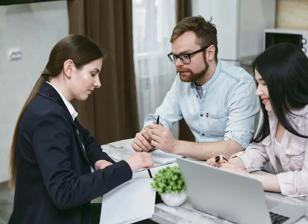 Couple consulting with a lawyer about the family provision claim NSW process at a desk with a laptop and documents.