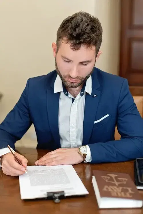 Man in a suit writing at a desk with documents related to notional estate orders in NSW.