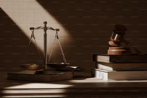 Scales of justice and a gavel on law books symbolize harsh and oppressive bylaws under dramatic lighting.