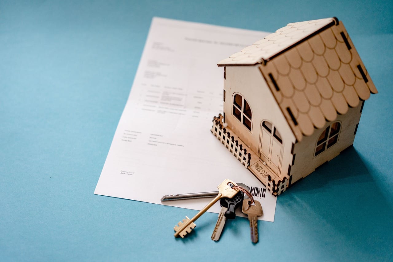 Model house and keys on legal document, symbolizing managing overseas assets and navigating international probate challenges.