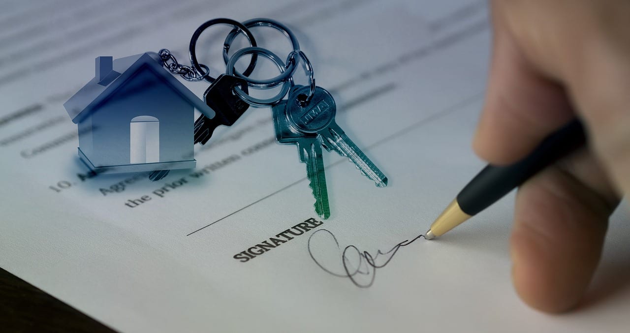 Hand signing a document with house keys, symbolizing Section 18C and 18D warranty rights under the Home Building Act NSW.