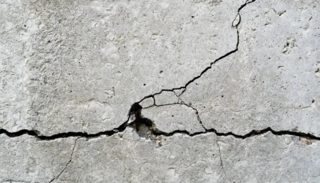 Cracked concrete surface highlighting building defects affecting owners' corporations' rights.