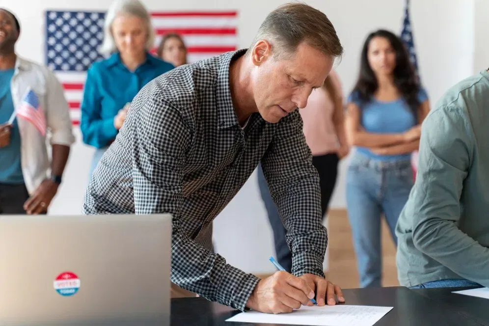 Man signing a document at a polling station.