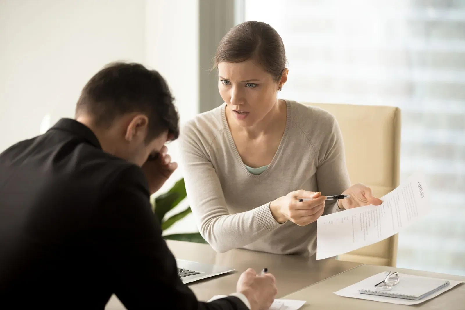 Frustrated woman points to contract, explaining duties to stressed man. NSW executor responsibilities.