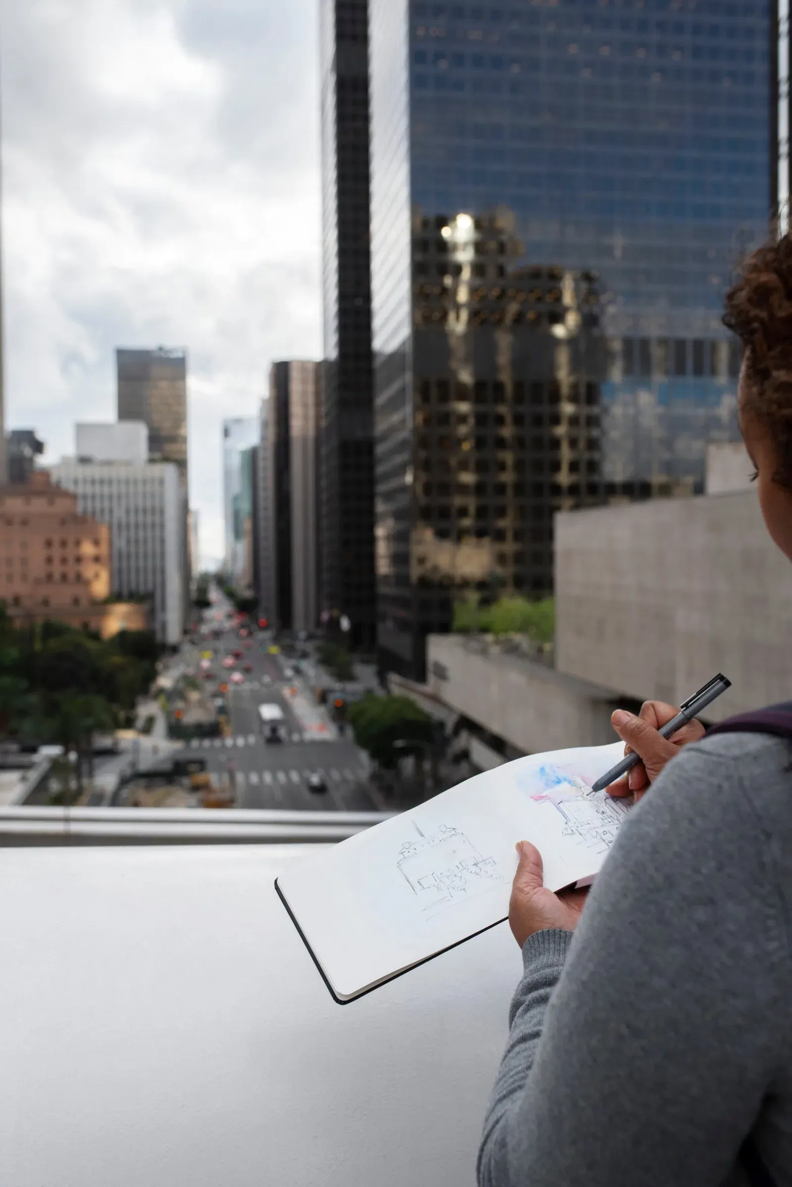 Person sketching city buildings, illustrating NSW construction 'fitness for purpose'.