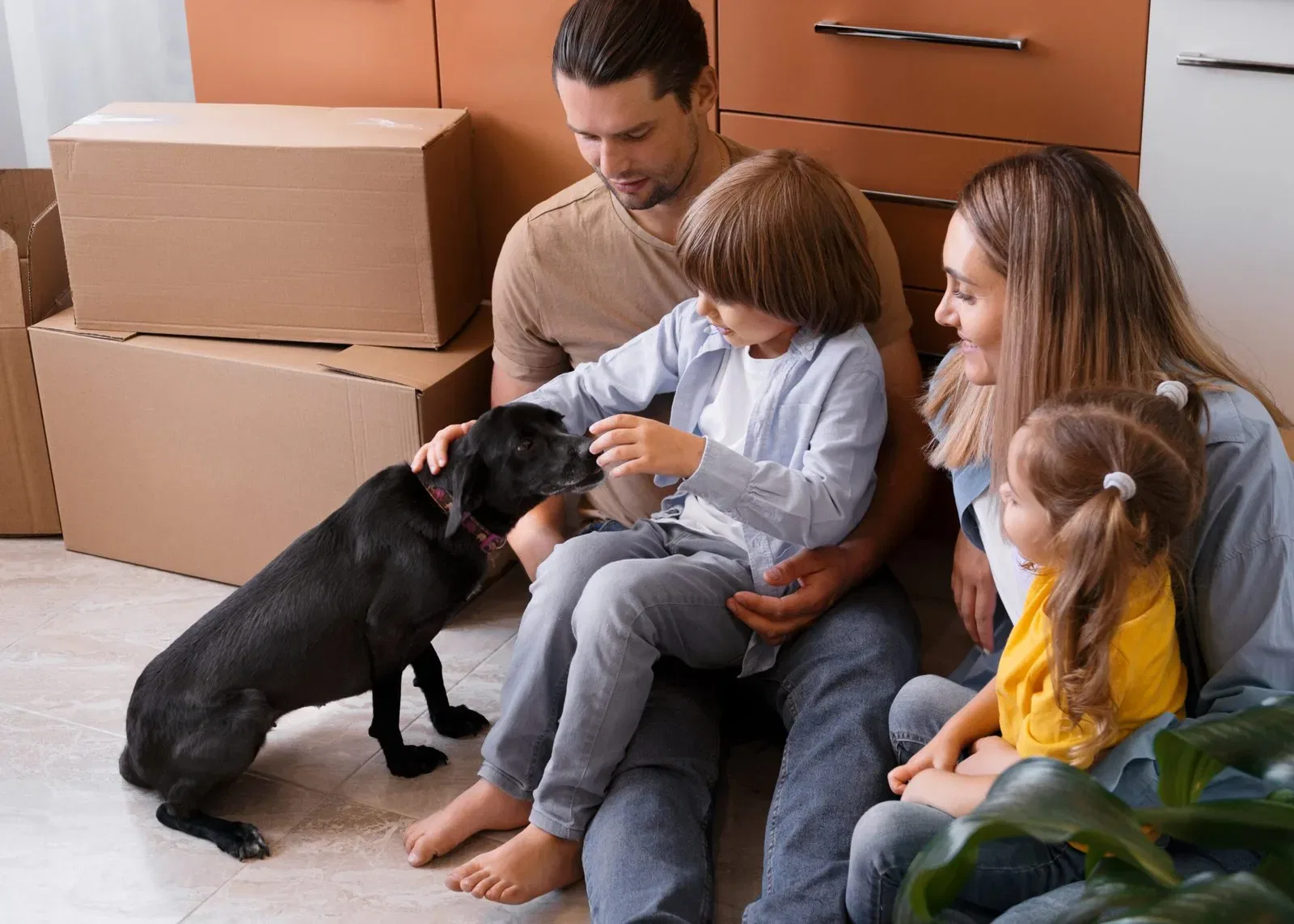 Family with young children and dog in new home, unpacking boxes. Pet custody considerations.