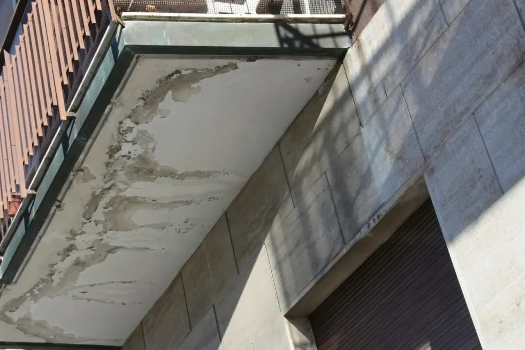 Damaged strata balcony ceiling showing water damage and peeling paint. NSW strata repair.