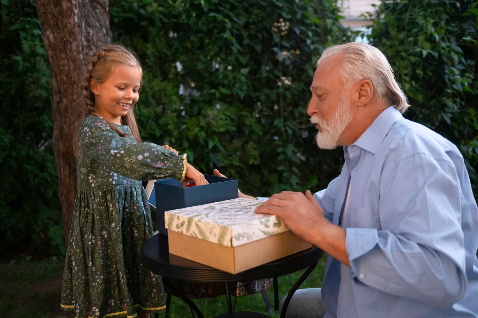 Grandfather and granddaughter exchanging gifts in garden