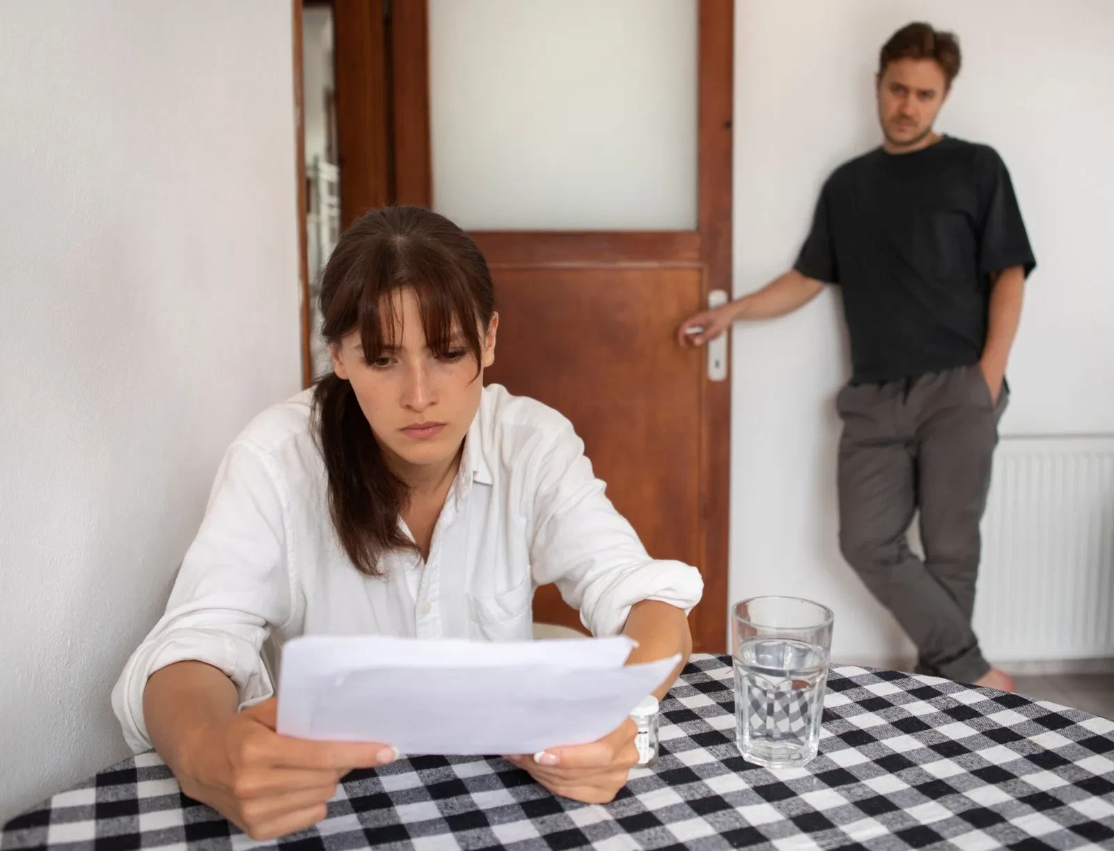 Woman reading legal document, man standing in background. Unfair will dispute in NSW?