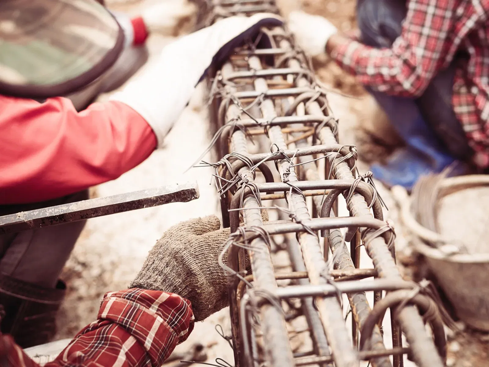 Construction workers installing reinforcing steel for a fence.