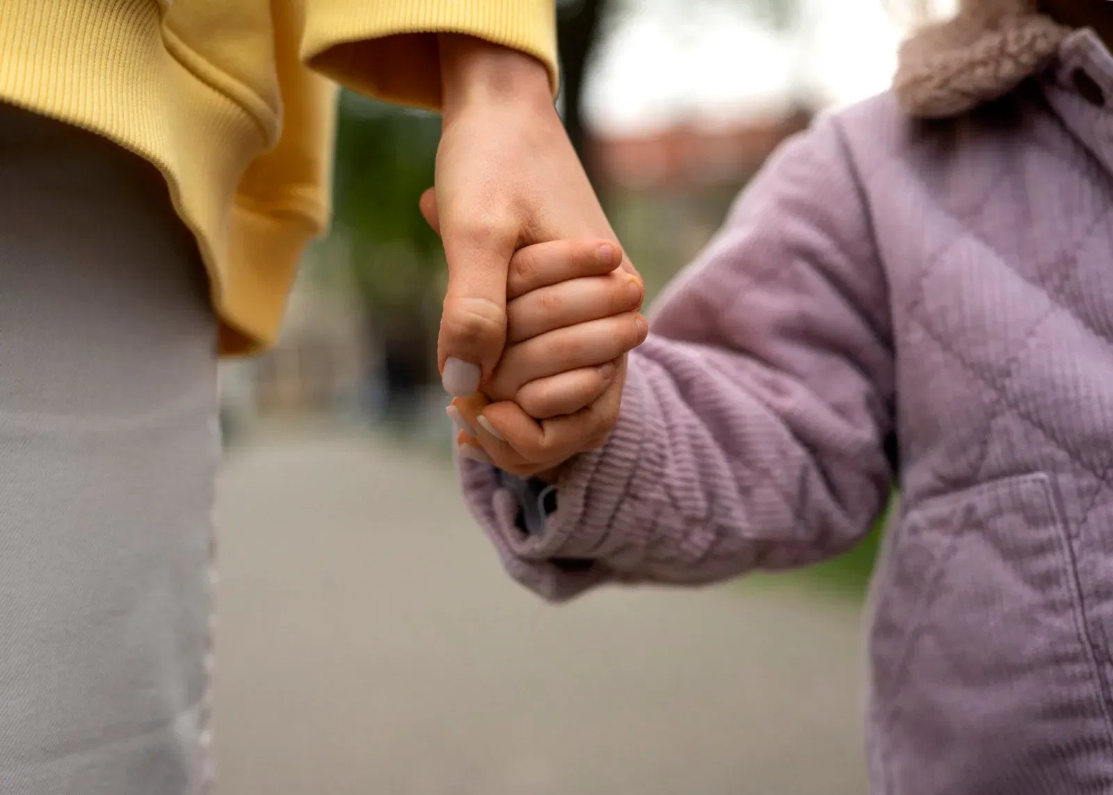Adult and child holding hands, symbolizing guardianship and care