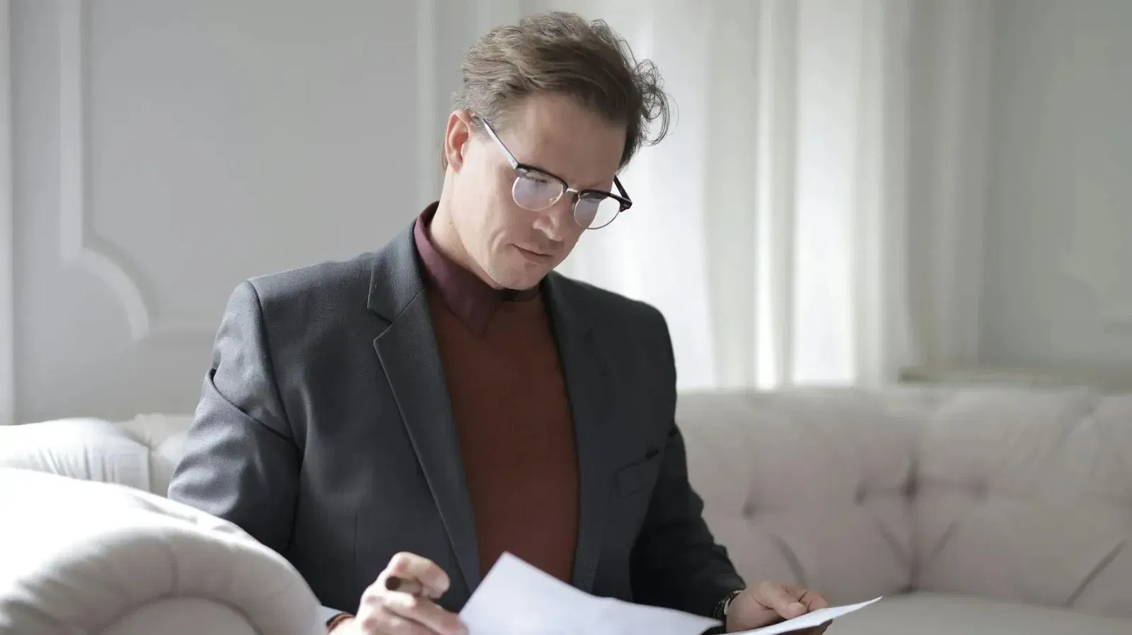 Man in glasses reviewing documents, possibly an intestacy lawyer.