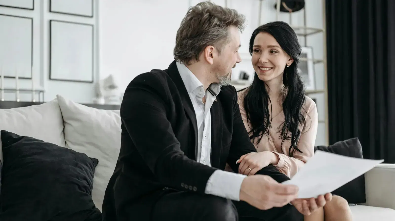Man and woman reviewing a will or estate document, smiling at each other