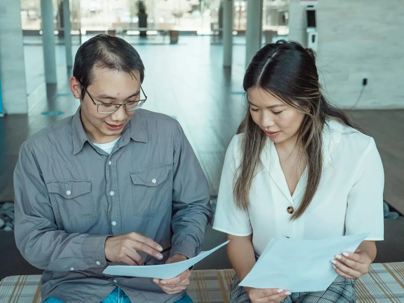 Two people reviewing documents together, possibly discussing estate planning or will details.