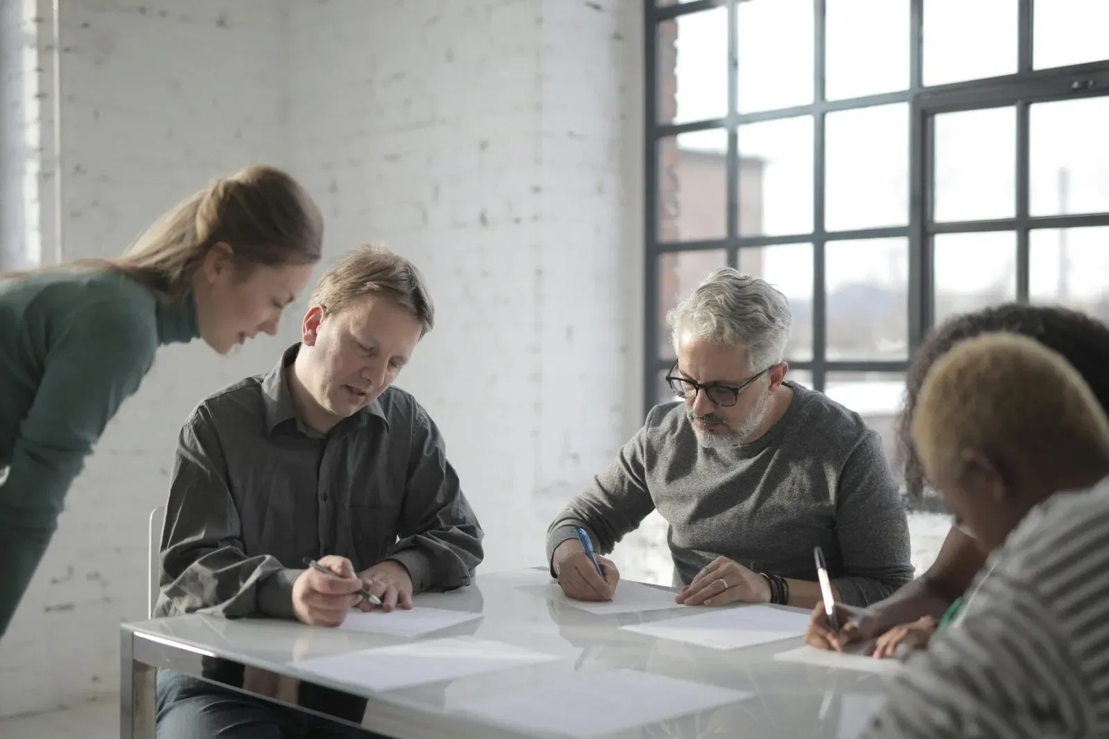 Group of people reviewing documents at a meeting table, discussing NSW Strata Law.