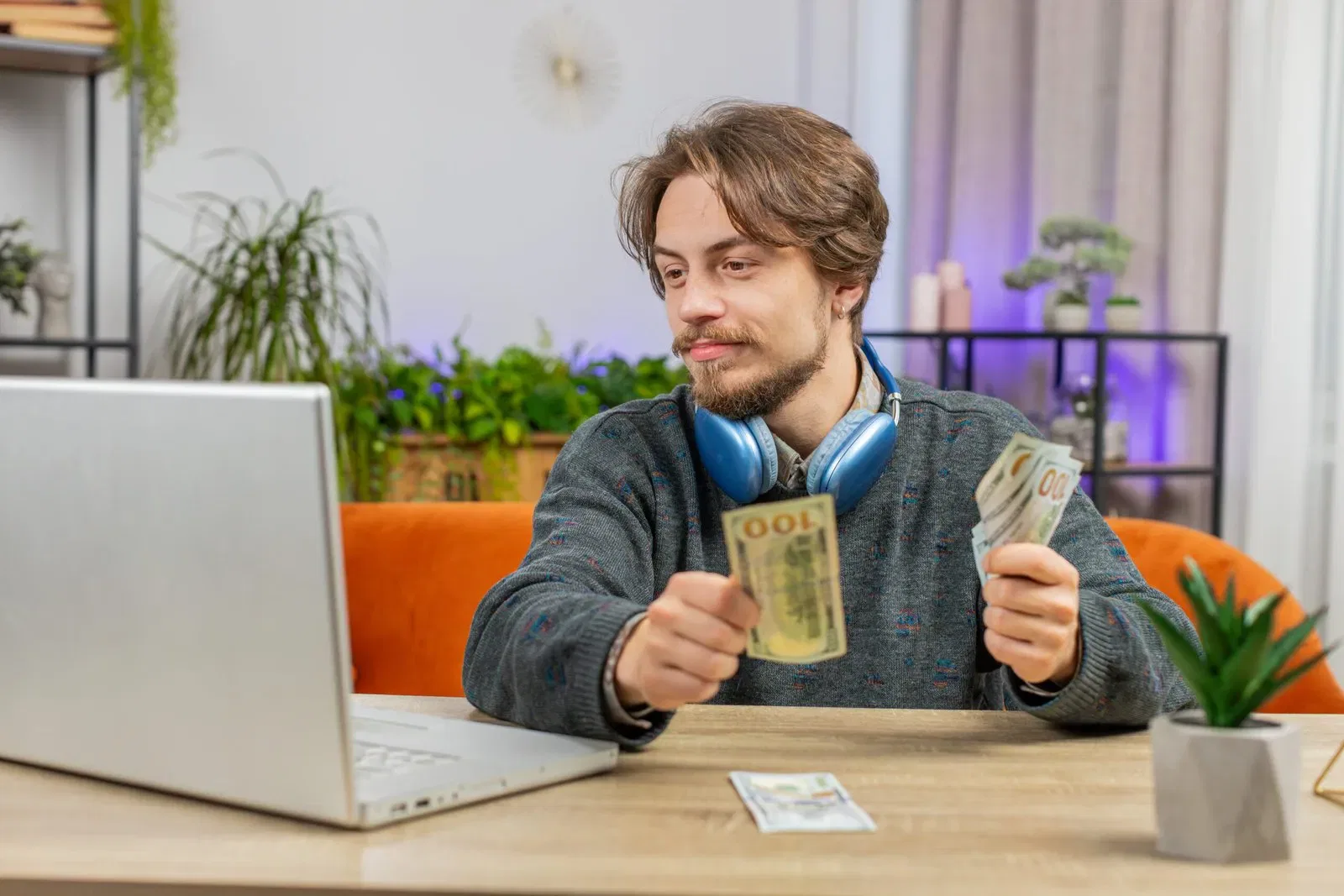 Content creator counting money while looking at a laptop, possibly related to taxes on gifts and products.