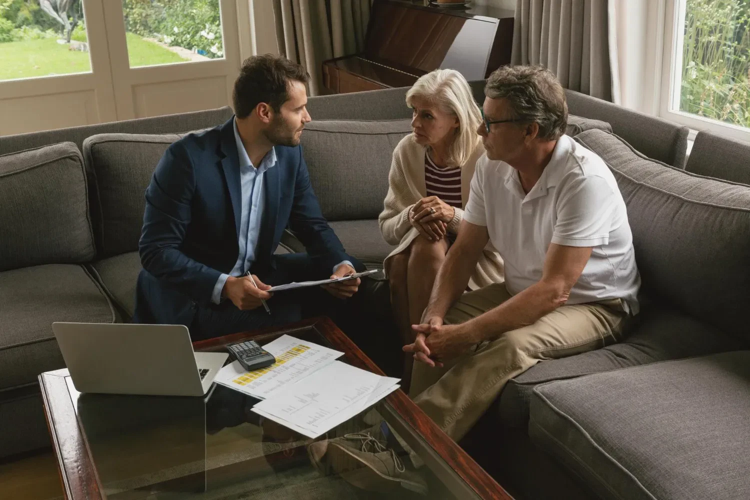 Financial advisor discussing informal wills with senior couple on a couch at home.