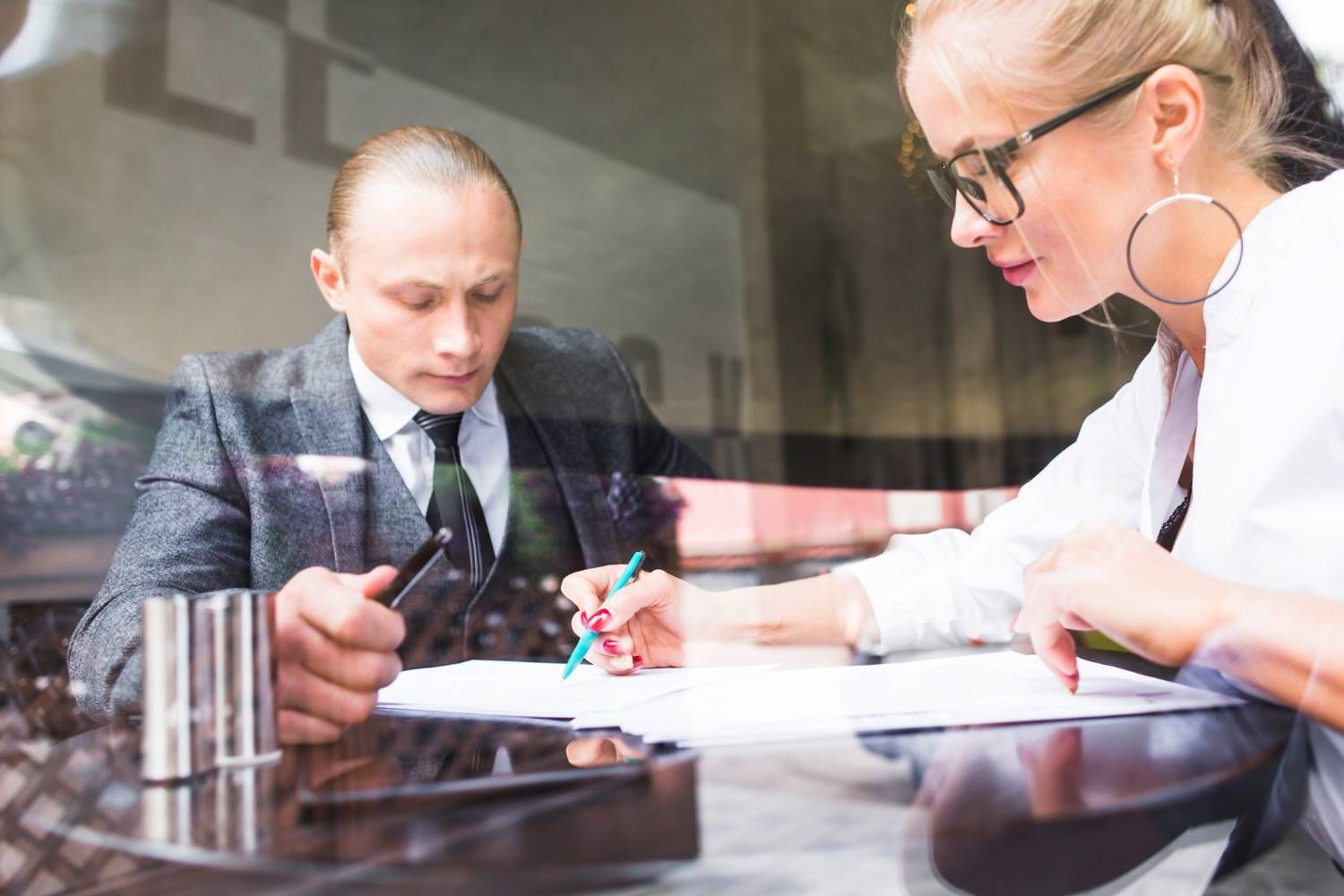 Business meeting: Man and woman reviewing documents, possibly discussing owners corporation legal issues.