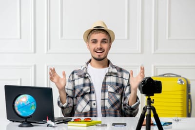 Travel blogger with globe, laptop, camera, and suitcase. Guide for global content creators.