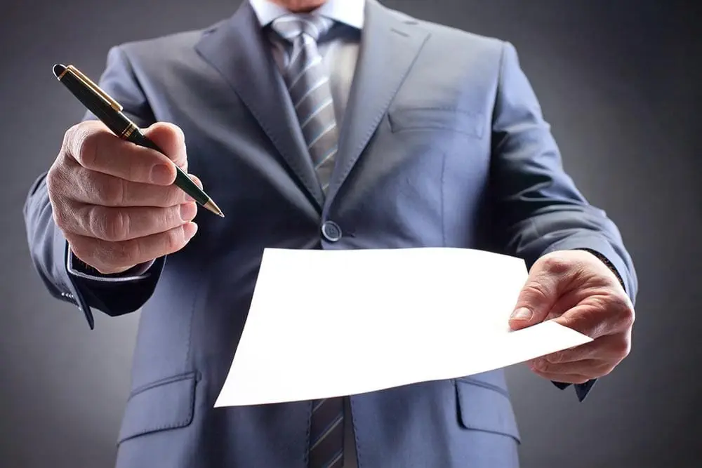 Businessman offering pen and contract for signature