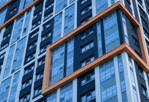 Modern apartment building exterior with large windows. NSW strata lot owners may experience rent loss due to building defects.