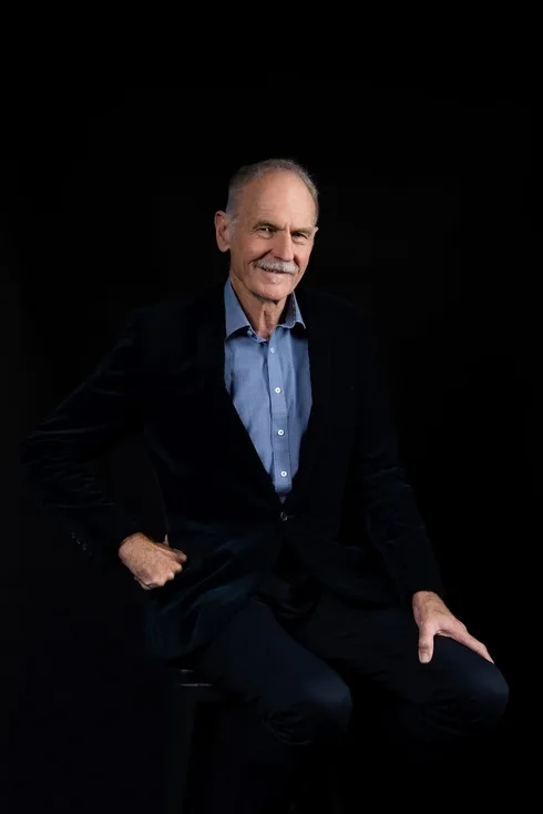 Smiling senior man in a dark suit and blue shirt