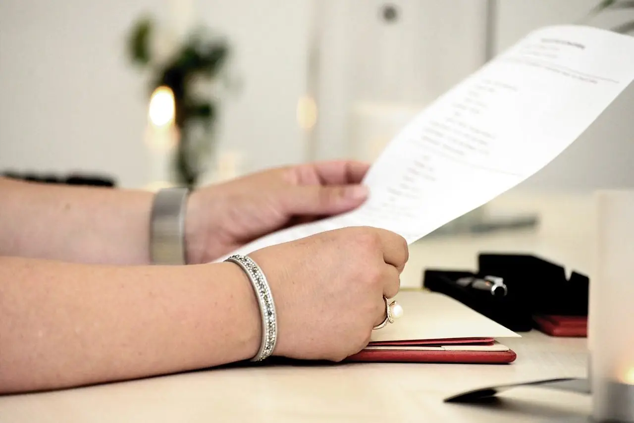 Person reviewing a document, possibly a will, at a desk, highlighting the process of challenging will validity in NSW.