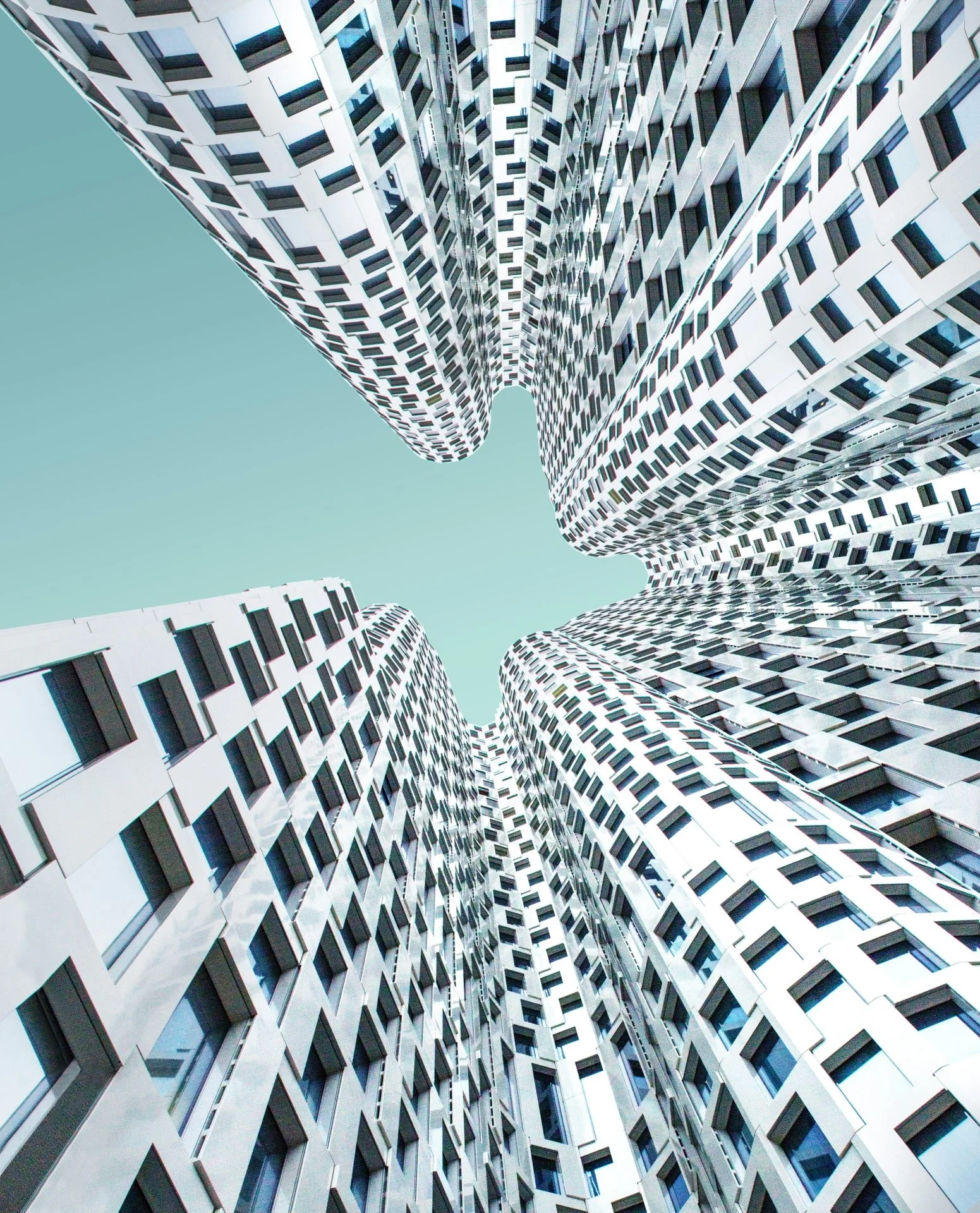 Modern high-rise buildings viewed from below, showcasing unique architectural design.