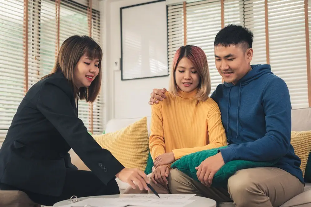 Financial advisor consulting with a Hong Kong couple about wealth planning.